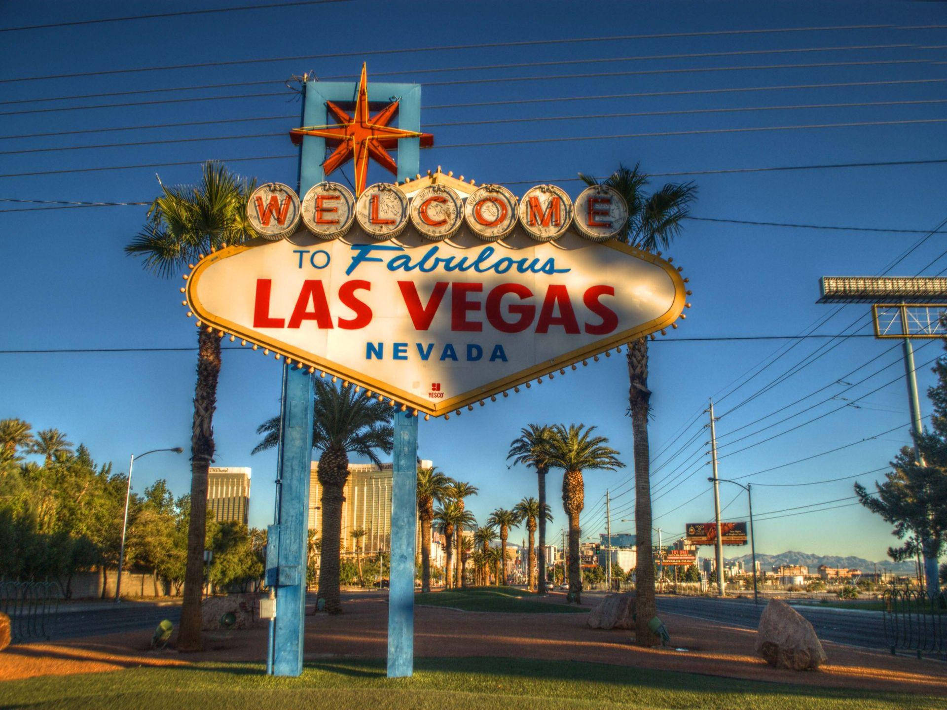歡迎來到日落時分的 Fabulous Las Vegas 標誌，伴隨著棕櫚樹和城市天際線。