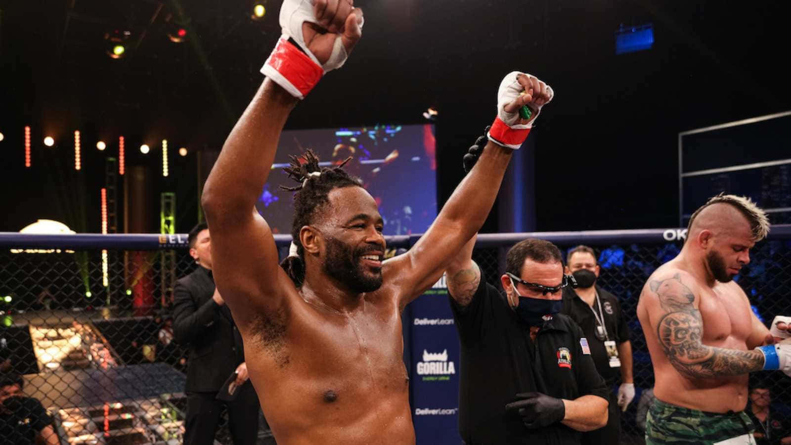 MMA拳手在八角籠內舉起拳頭慶祝勝利。