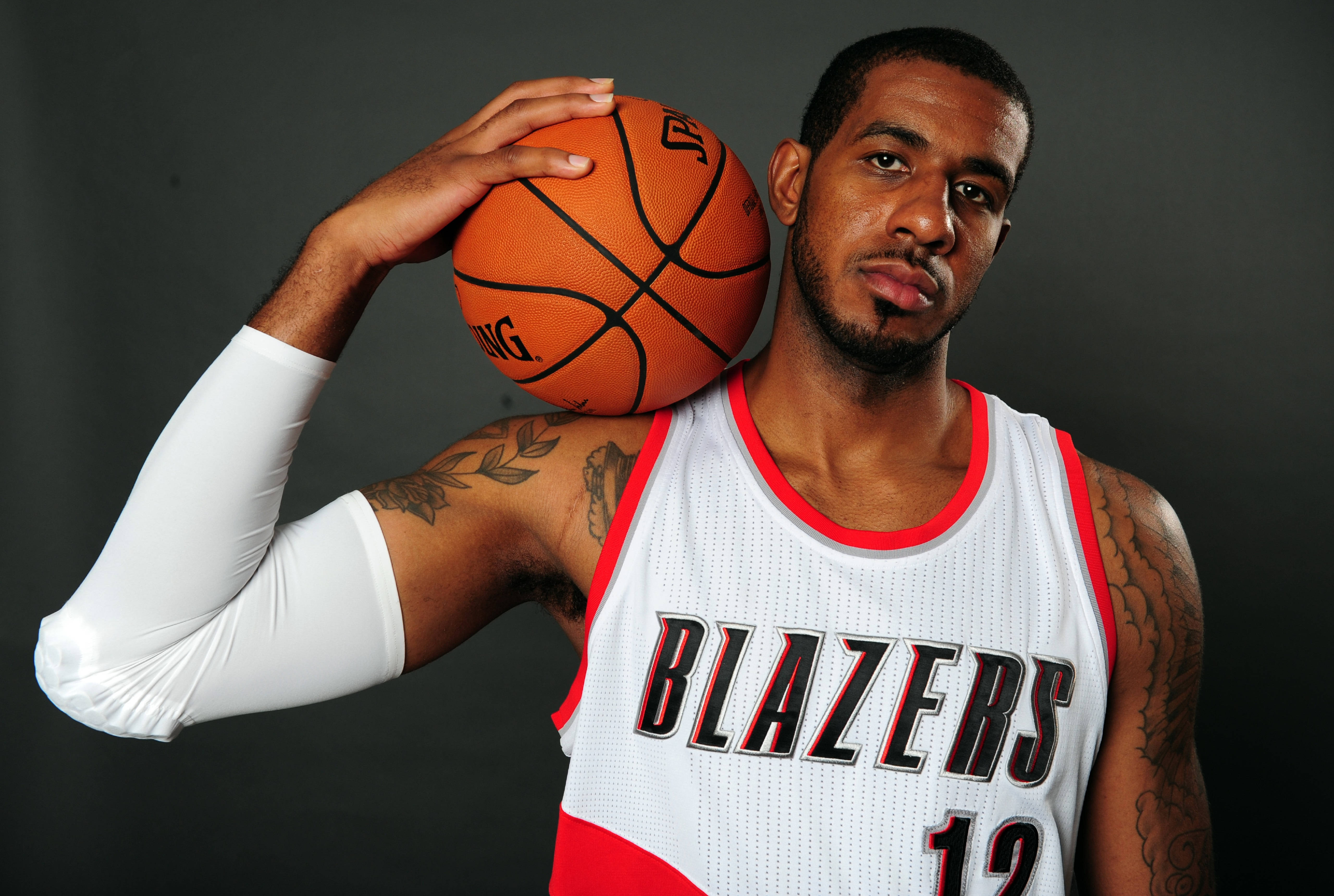 拉馬庫斯·阿爾德里奇肖像 壁紙 — 一位身穿 Blazers 球衣的籃球運動員將球靠在肩上，手臂上的紋身清晰可見。