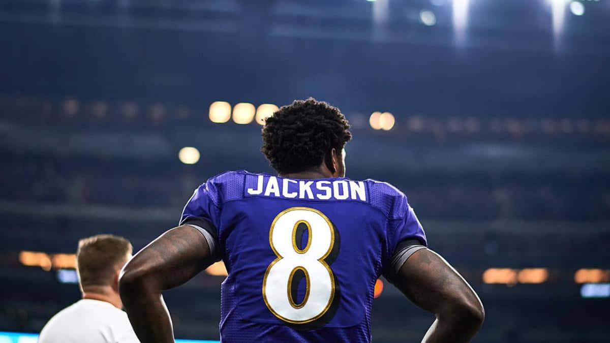 美式足球員Jackson 8號夜晚站在體育場。