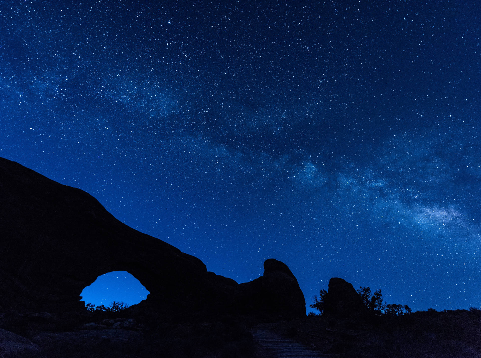 在繁星點點的夜空下，岩石拱門的剪影，銀河系清晰可見。