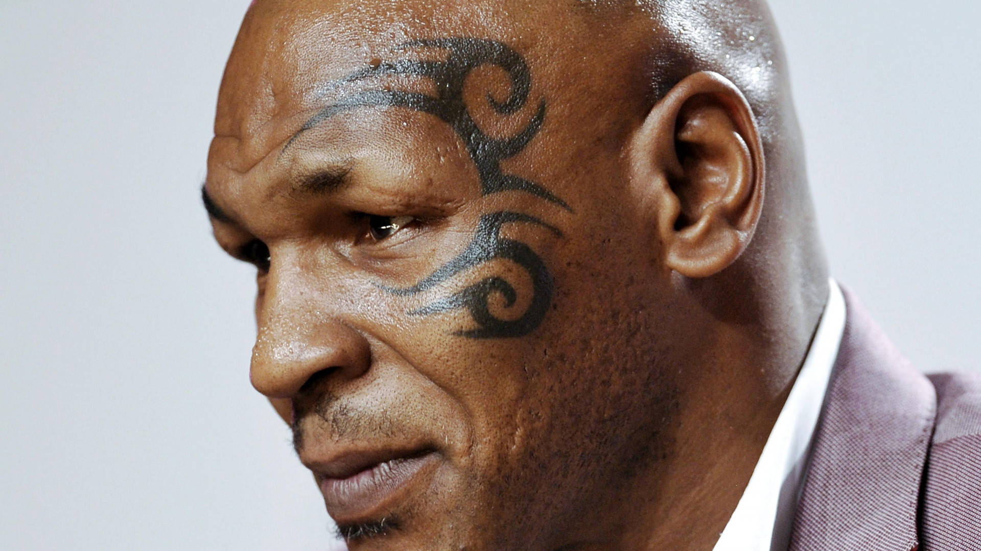 拳王邁克·泰森面部紋身特寫 壁紙 — Mike Tyson 臉部特寫，展示他面頰上標誌性的部落紋身和嚴肅表情。