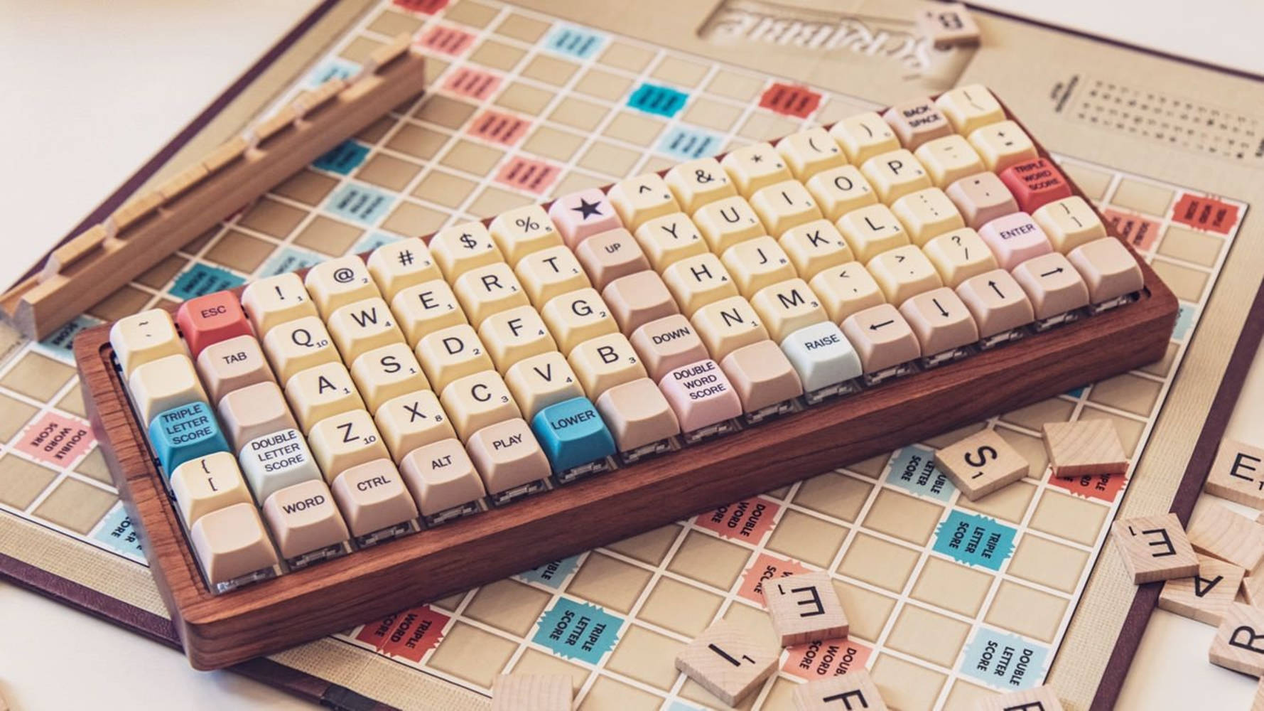 帶有粉彩色按鍵的木製鍵盤，放置在帶有字母牌的Scrabble棋盤上。