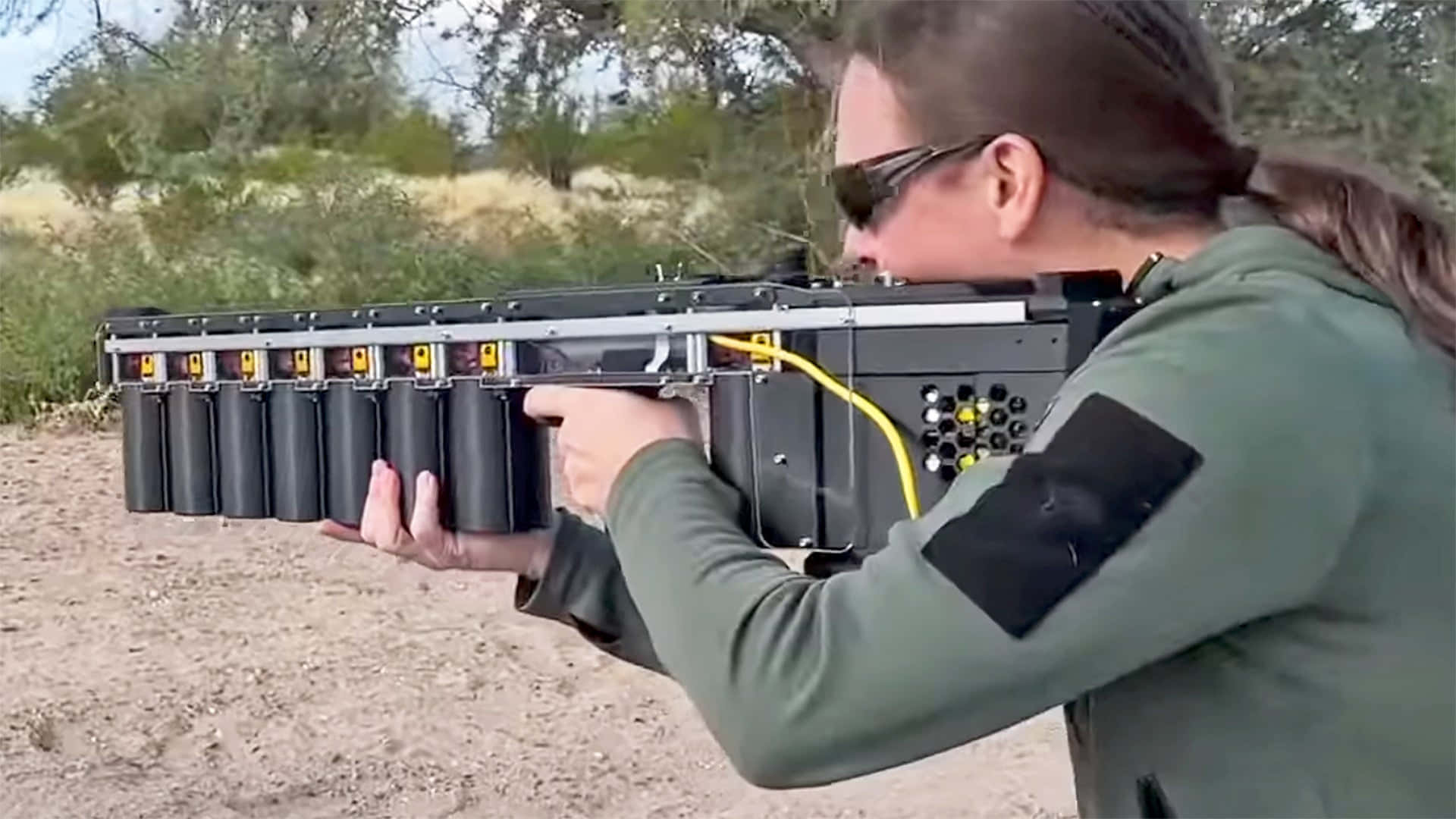 在沙漠地形中瞄準自製多管發射器的人。