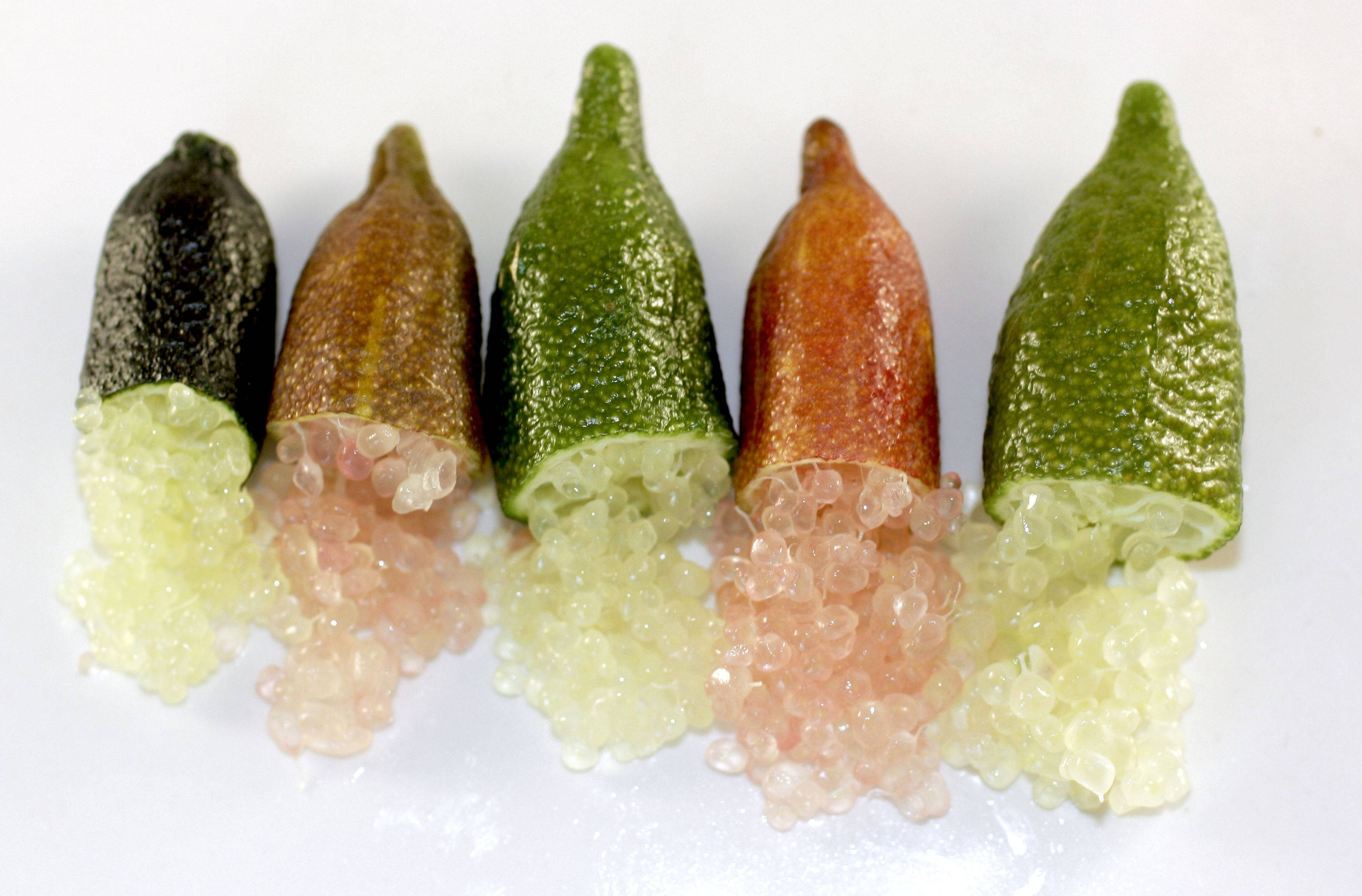 指 lime 果實的不同顏色 壁紙 — 五條色彩繽紛的秋葵莢被切開，露出半透明的粉紅色和淡黃色珠狀種子，背景為純白色。