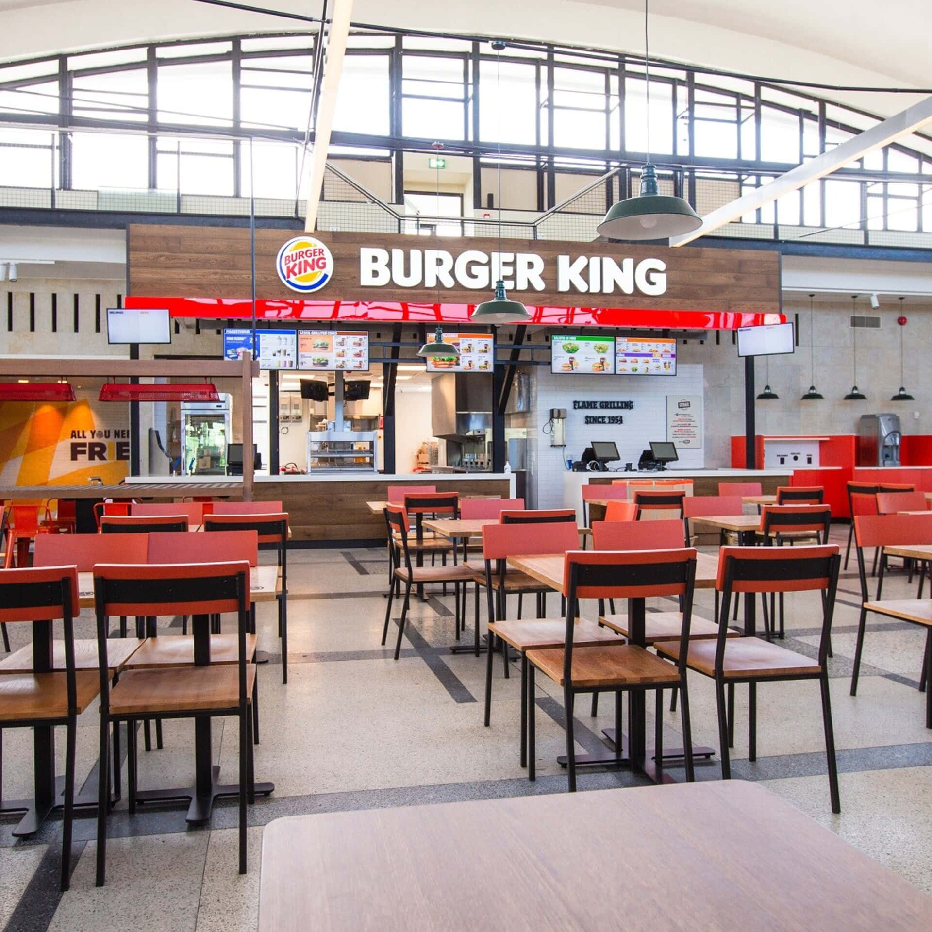 Burger King餐廳內部，配有紅色椅子和木桌，光線明亮。