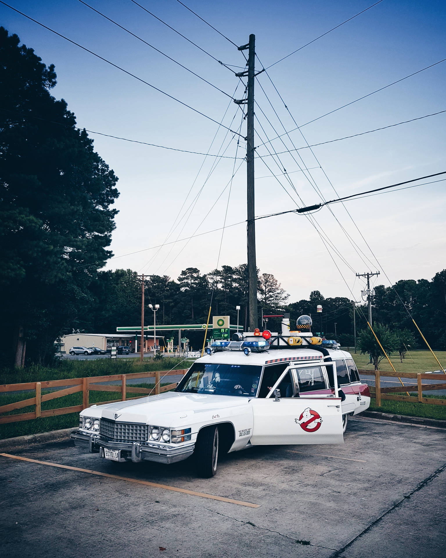 白色捉鬼敢死隊Ecto-1汽車在黃昏時停放在加油站。