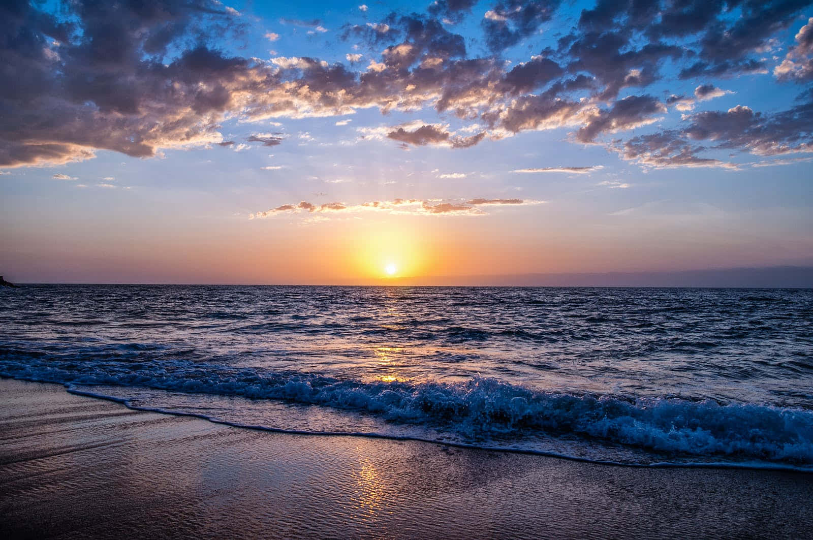 海洋上的夕陽，海浪滾滾湧上沙灘