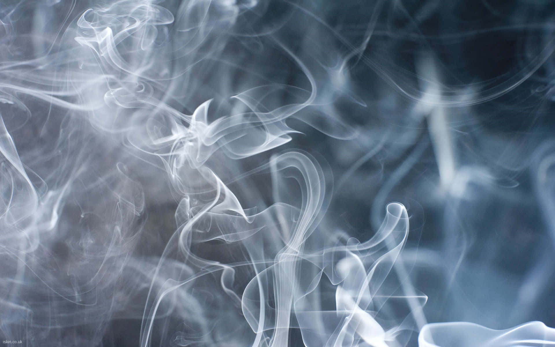 捕捉未知魔幻感的絕美飄渺背景 壁紙 — 縷縷白煙如夢似幻，在清涼的藍灰色背景上盤旋扭轉，上演一場迷人的抽象舞蹈。