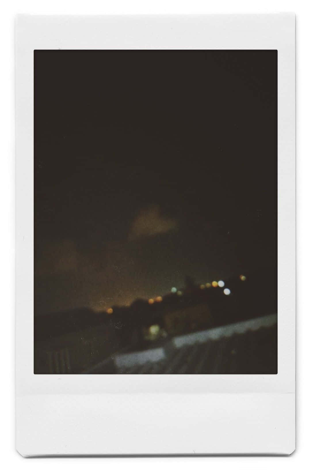 模糊的夜間城市景觀，帶有遠處燈光，置於寶麗來邊框中 — 寶麗來 GIF 壁紙