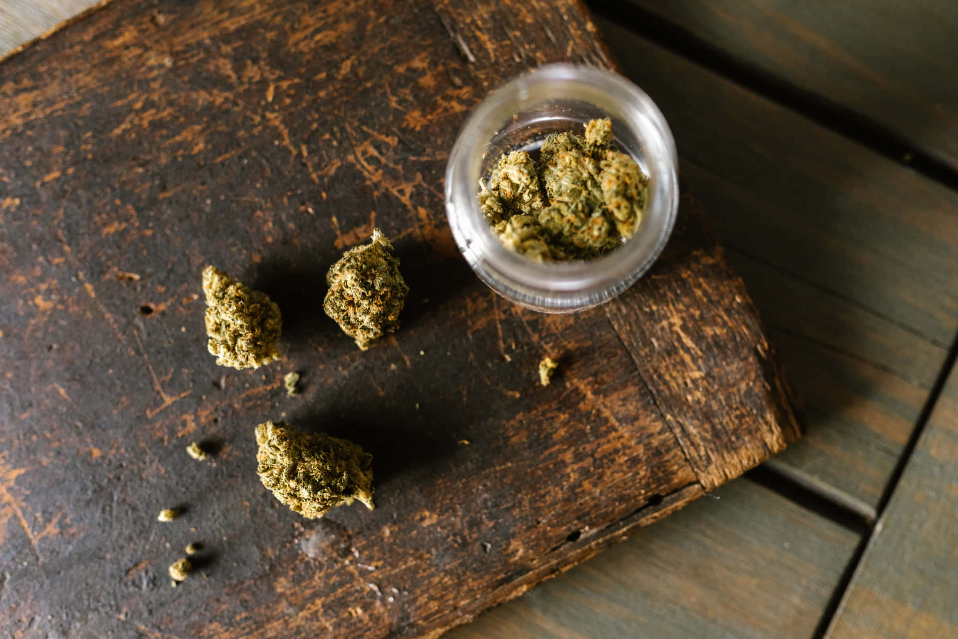 大麻花蕾在質樸的木頭上與玻璃罐