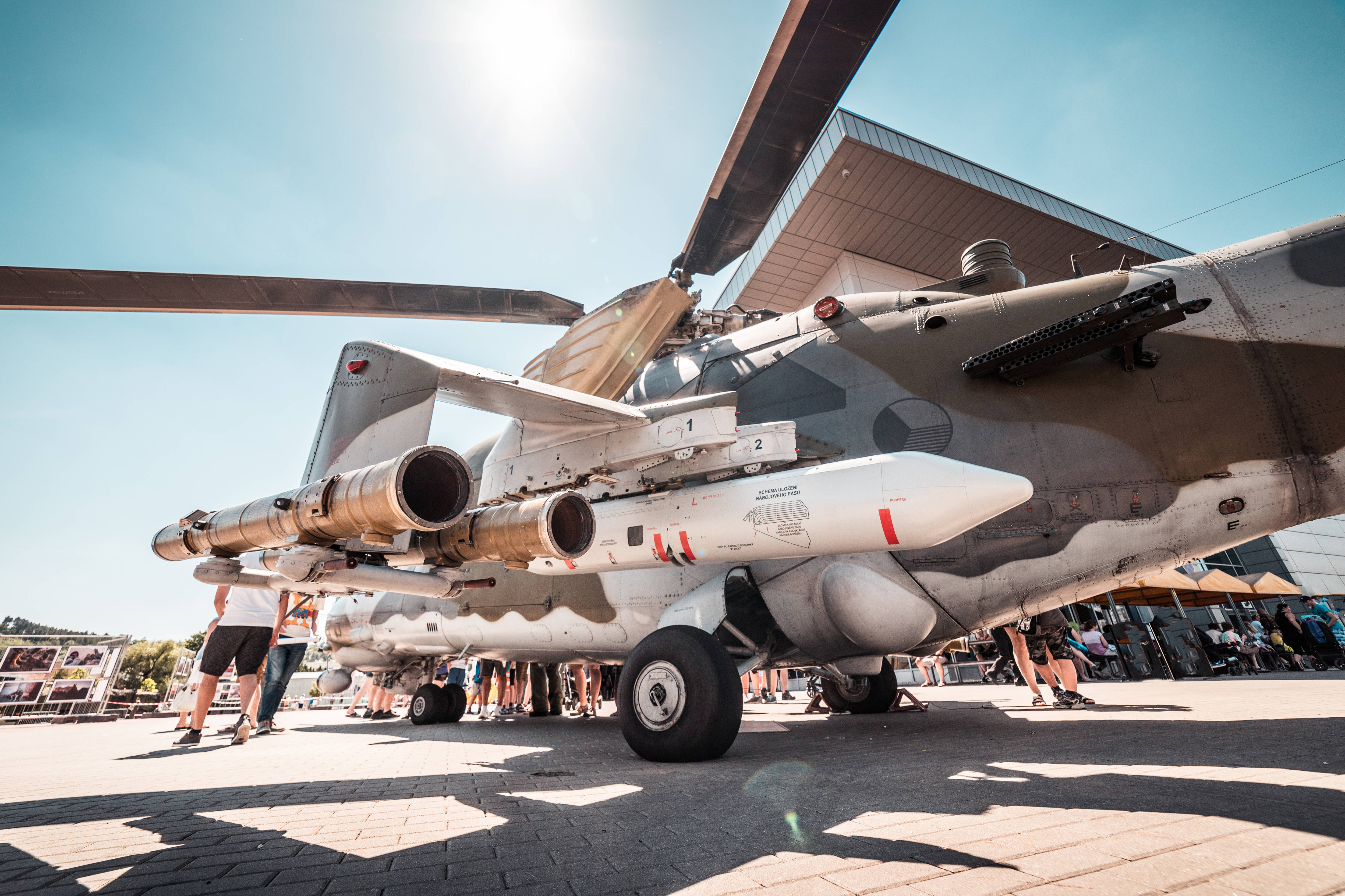 捷克軍隊直升機4K 壁紙 — 低角度拍攝的軍用直升機，在戶外航空展上展示導彈，陽光燦爛。