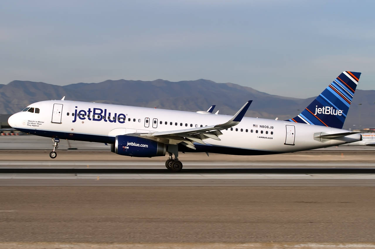 JetBlue飛機喺跑道上，背景有山