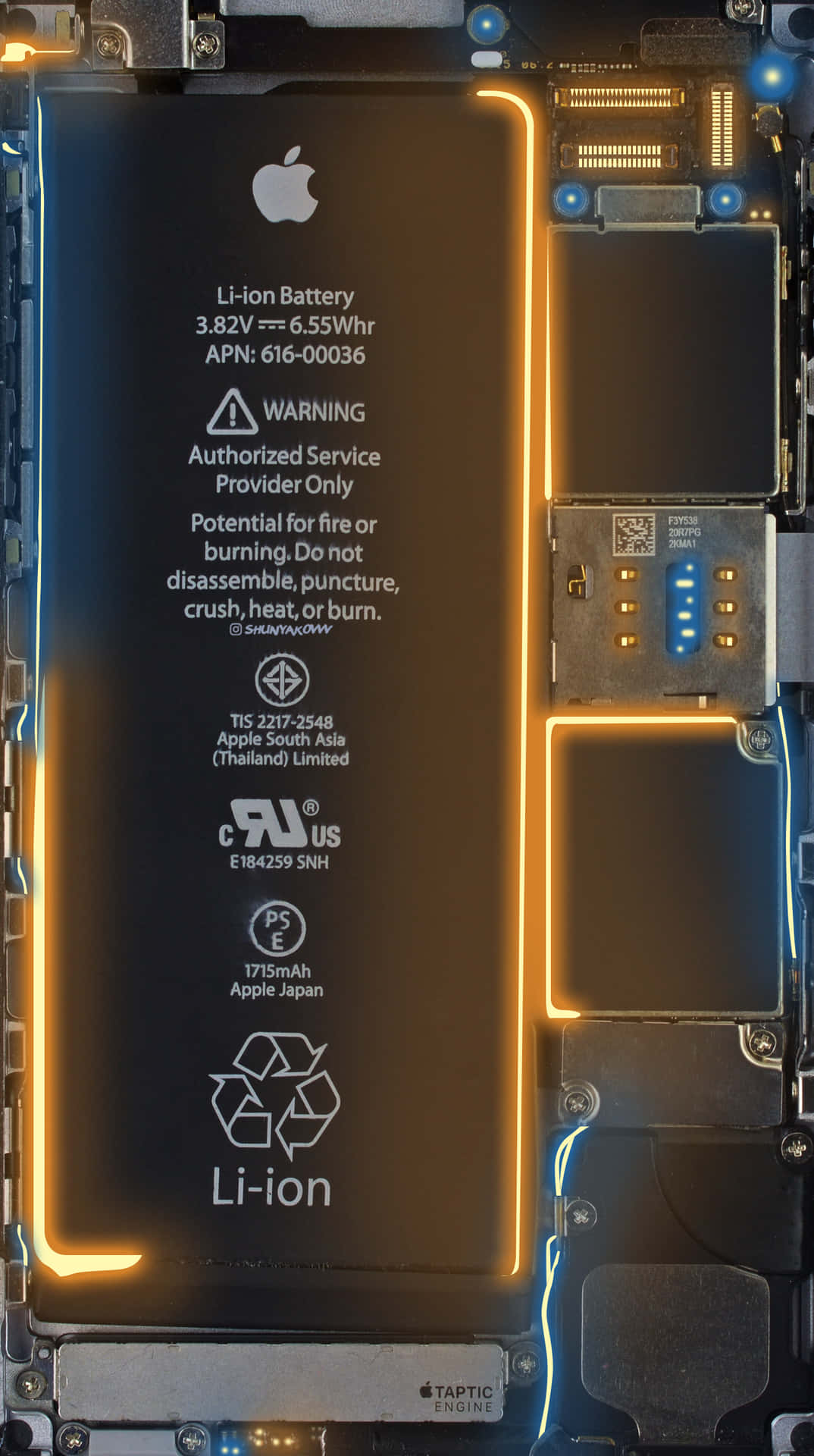 帶有發光橙色電路和警告標籤的 iPhone 電池。