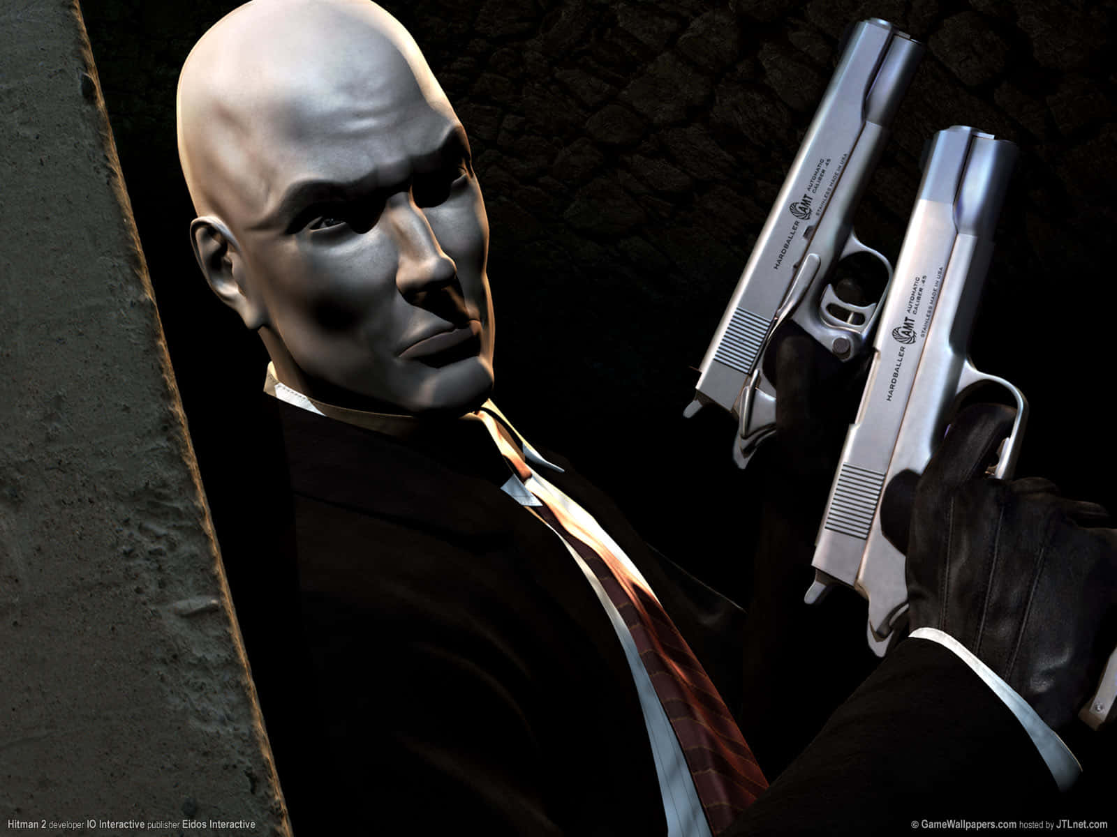 掌握全局：踏入《Hitman 2》世界 壁紙 — 一名身穿西裝的光頭刺客，在戲劇性的燈光下，手持兩把銀色手槍，背靠深色石牆。