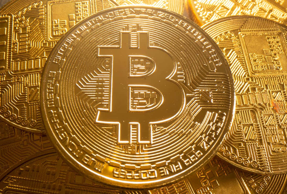 一堆帶有電路板設計的金色比特幣硬幣。