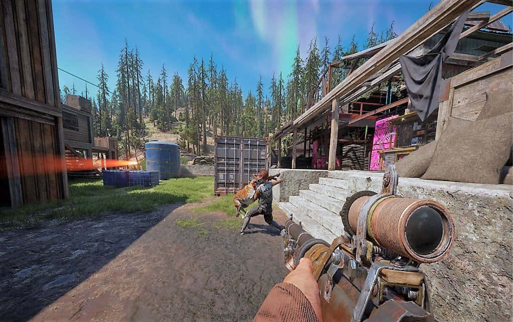 探索《Far Cry 新黎明》末日世界 壁紙 — 第一人稱射擊視角，在一個被松樹環繞的質樸木製建築群中，在晴朗的藍天下用步槍瞄準敵人。