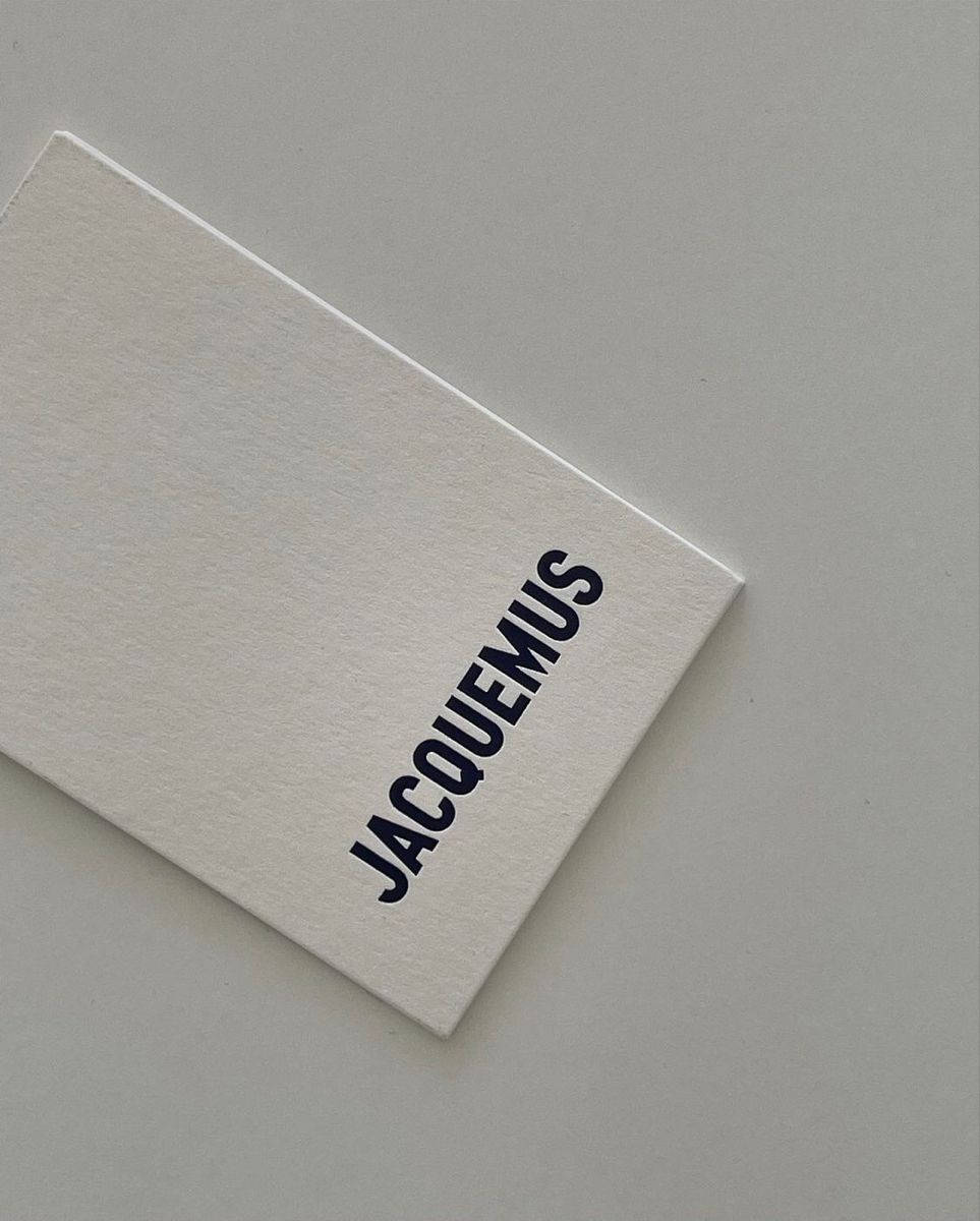 灰色背景上帶有黑色Jacquemus文字的白色卡片