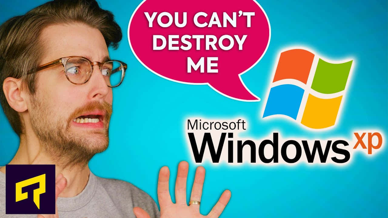 戴眼鏡和鬍鬚的男人對 Windows XP 標誌和寫著「你無法摧毀我」的對話框做出震驚的反應。