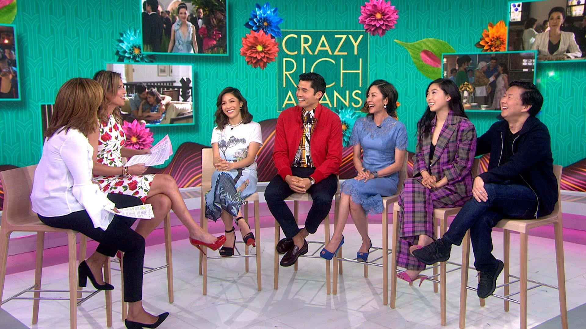 六個人在「Crazy Rich Asians」的彩色電視錄影廠佈景中坐在凳子上大笑。