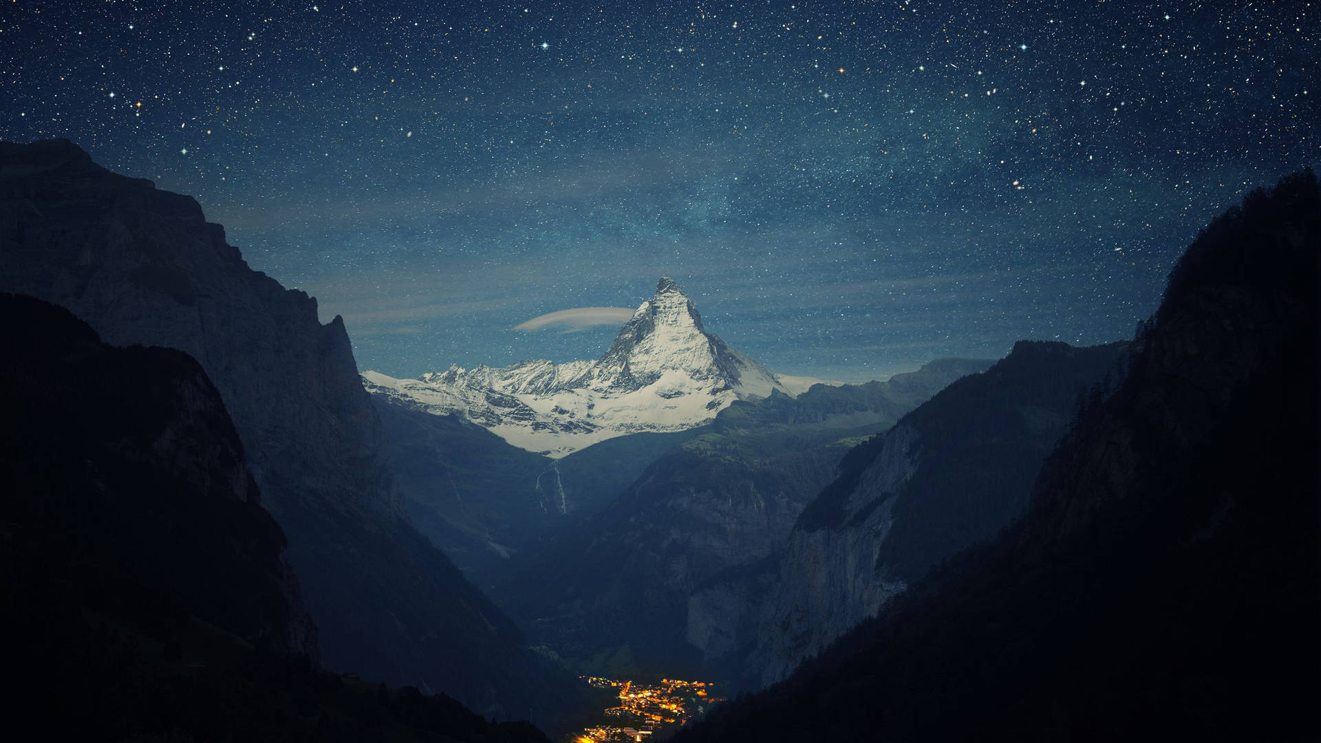 星空下白雪覆蓋的山峰，下方發光的村莊