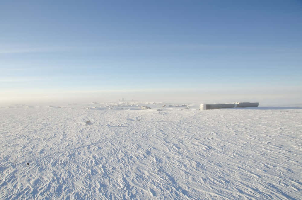 藍天清澈，雪原上有混凝土建築。