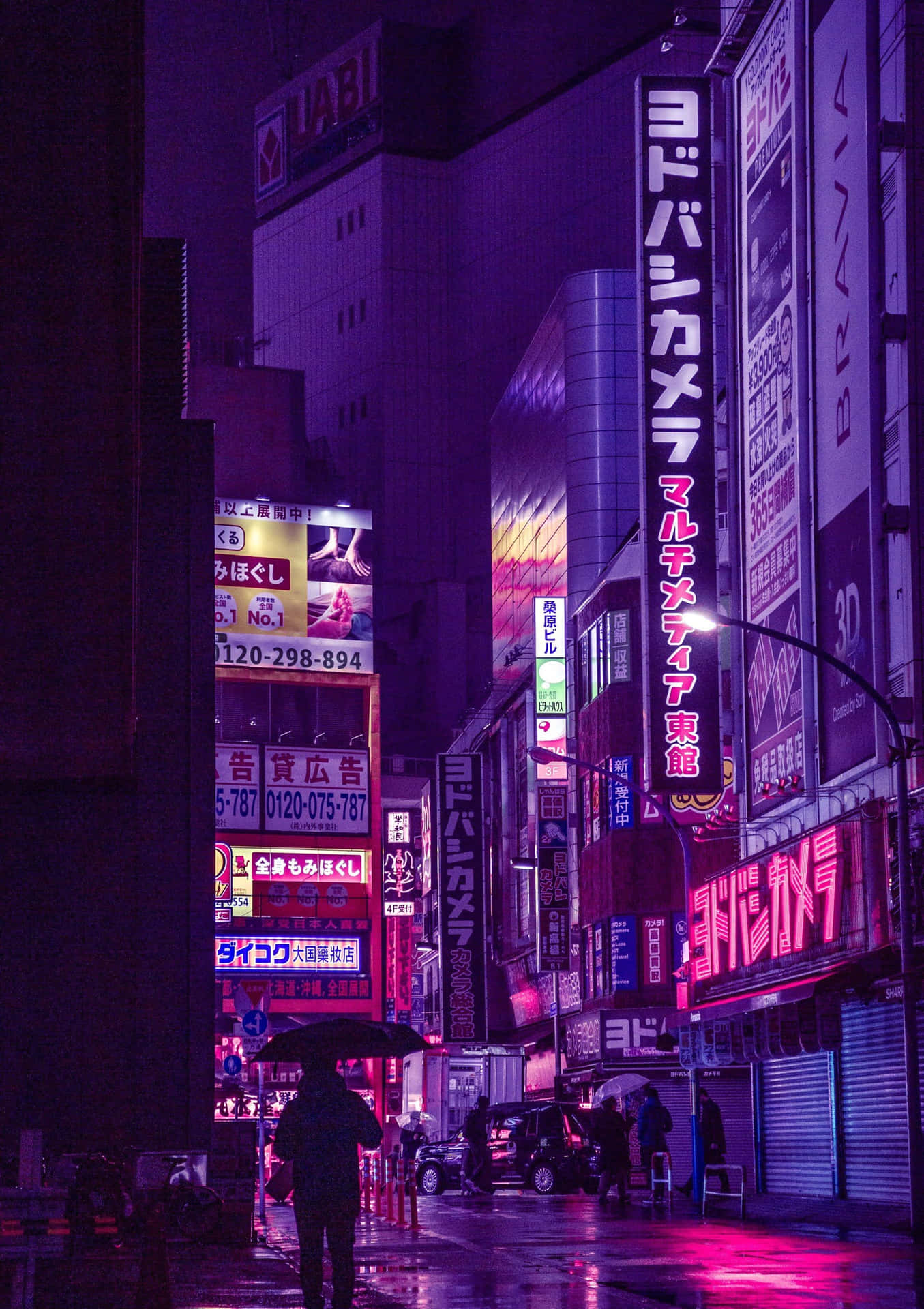 在霓虹燈照亮的雨夜東京街道上撐傘行走的人。