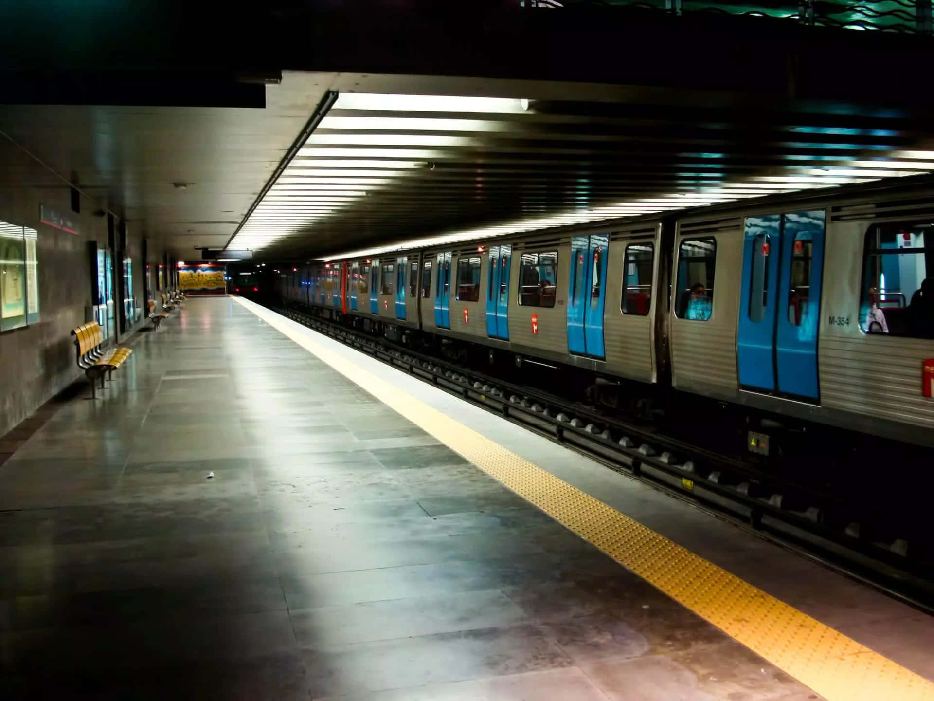 地鐵列車停在空無一人的車站月台，帶有黃色安全線。