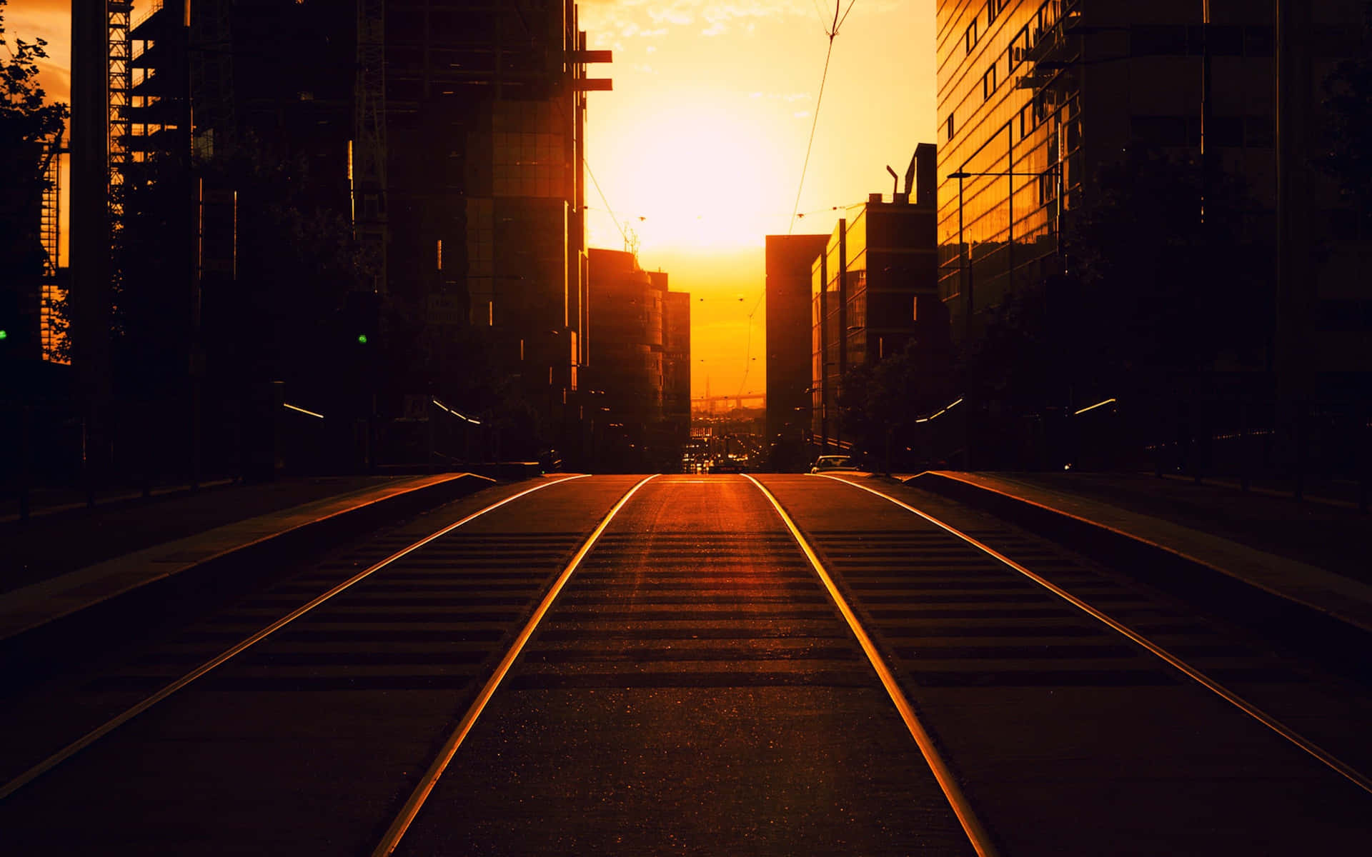 城市上空的夕陽，電車軌道通向地平線