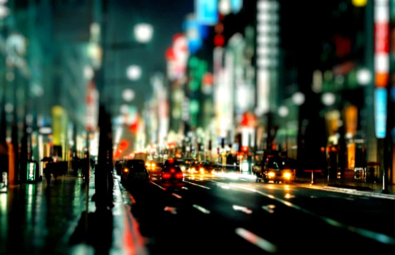 探索夜之城霓虹燈輝煌的巷弄 壁紙 — 雨夜中濕漉漉的城市街道，模糊的霓虹燈和流動的車頭燈營造出夢幻般的都市光芒。