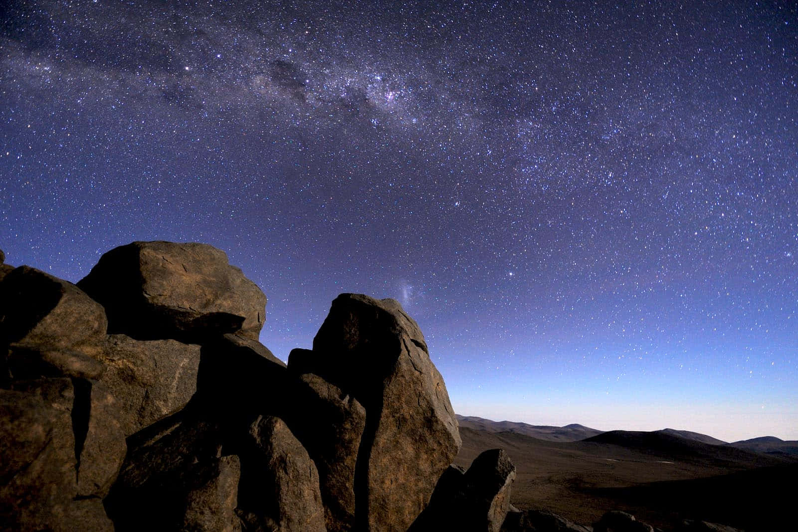 在可見銀河的星空夜空下的剪影岩石。