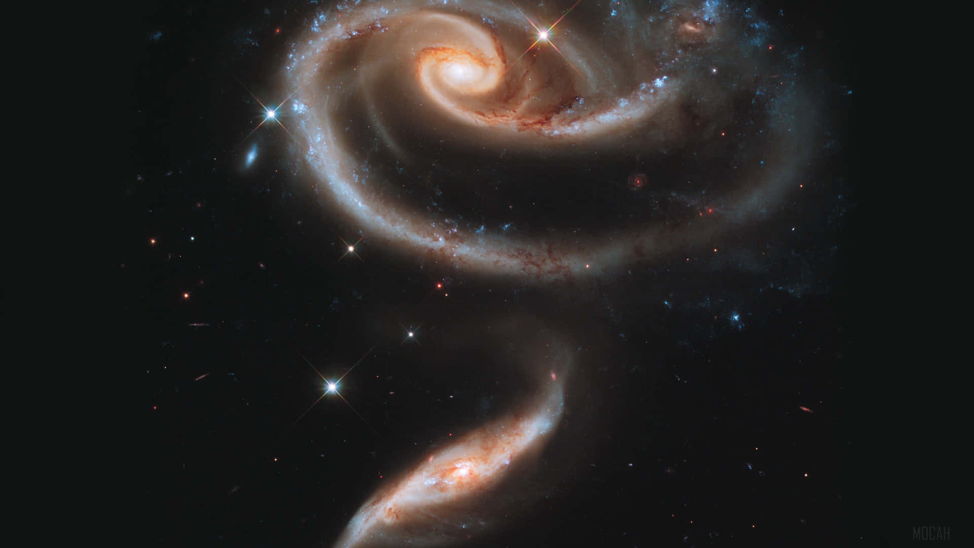 兩個螺旋星系在星光閃爍的黑色天空中進行宇宙碰撞之舞。