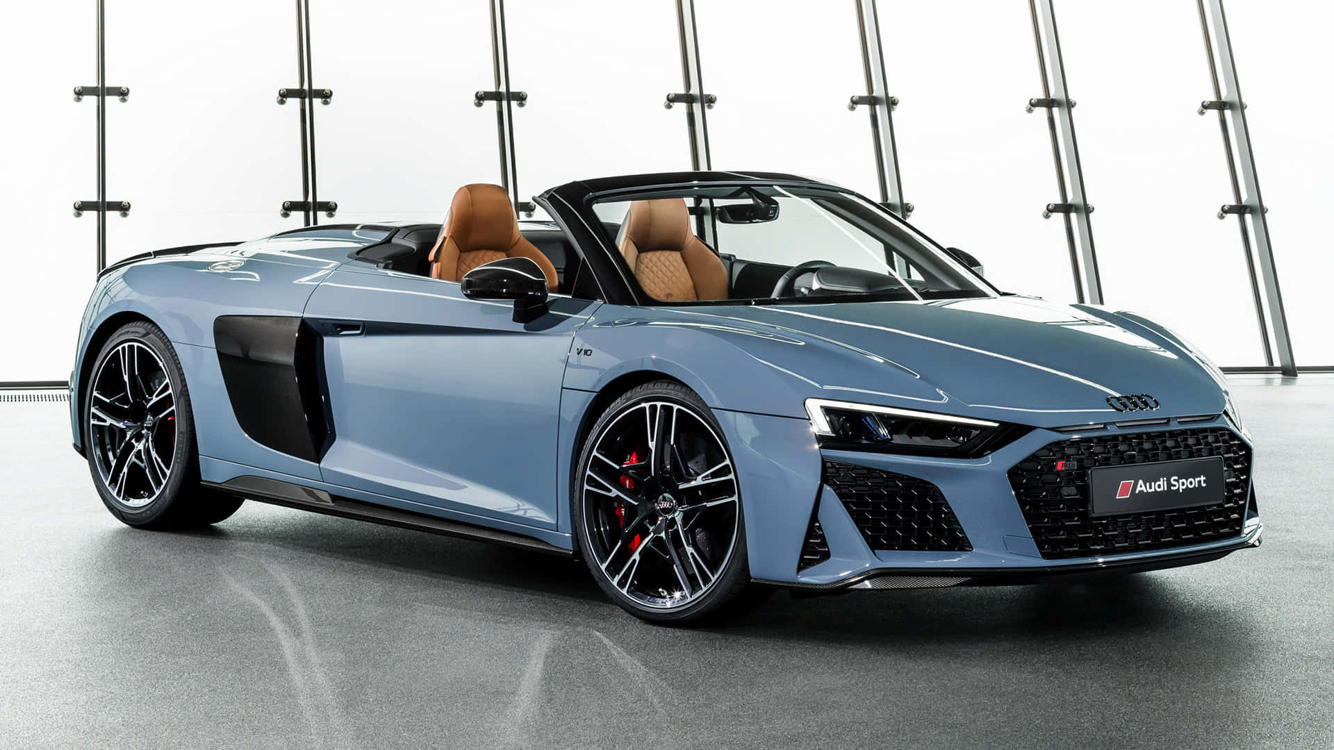 探索奧迪A6的動力與奢華 壁紙 — 一輛時尚的淺藍色奧迪R8 Spyder敞篷車，配備棕色皮革座椅，在極簡主義工作室中展示，周圍是工業金屬橫樑和拋光混凝土地板。
