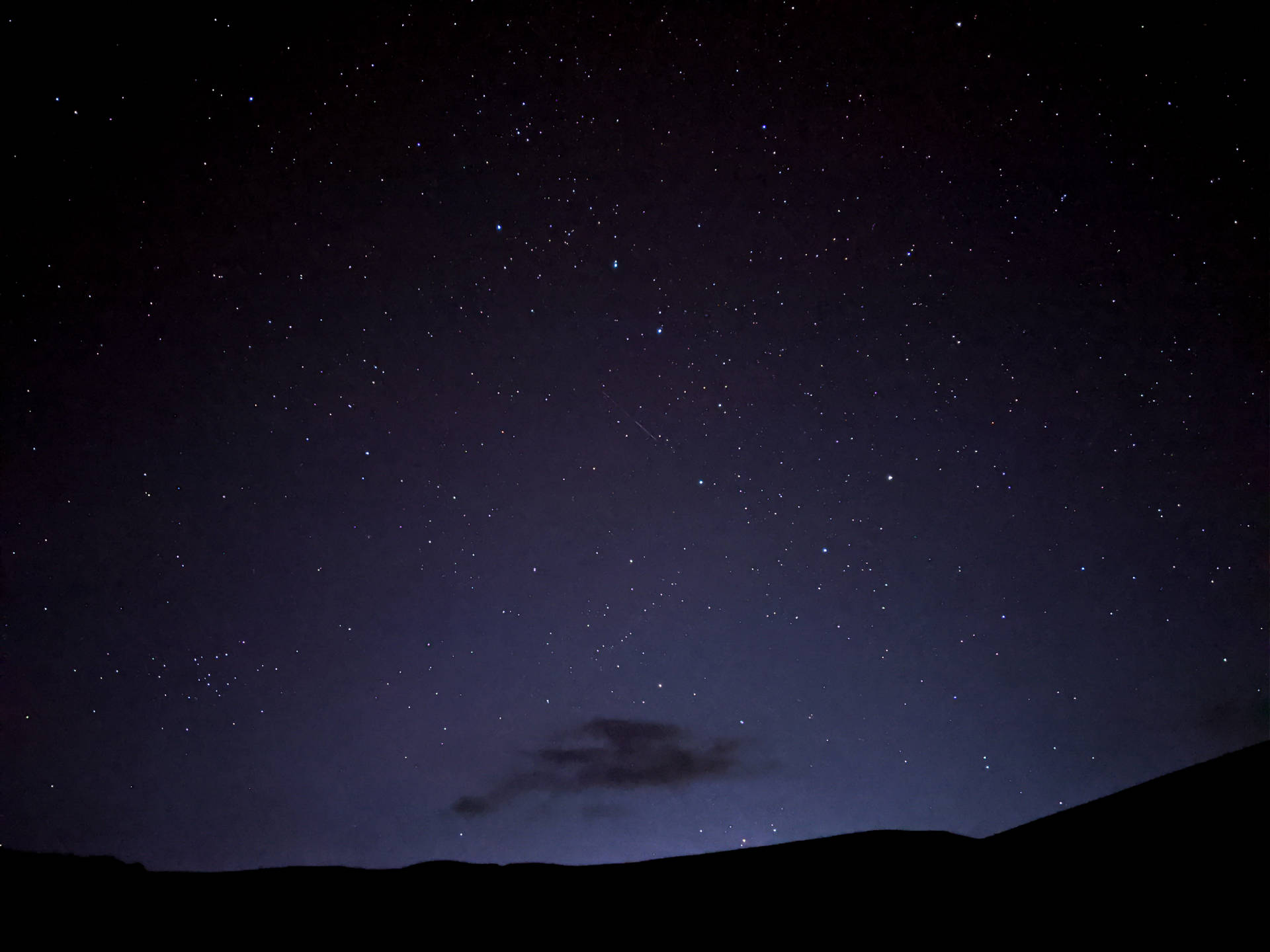 繁星點點的夜空，有流星劃過黑暗的山丘和雲。