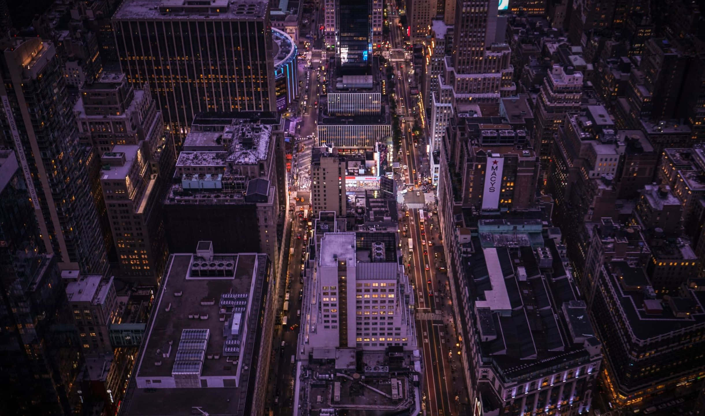探索帝國大廈，2440x1440 背景 壁紙 — 夜晚密集城市的鳥瞰圖，有發光的街燈和照亮的高樓大廈。