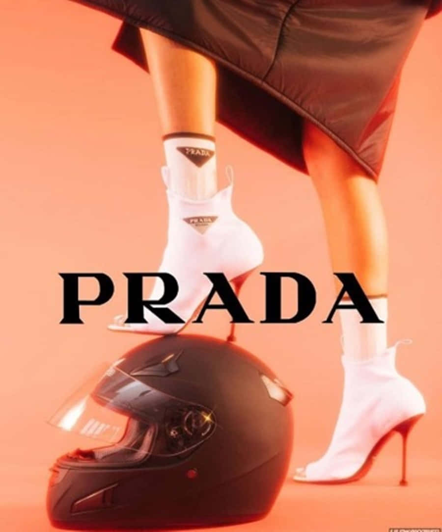 探索我們新壁紙上的奢華普拉達品牌 壁紙 — 一位穿著白色Prada踝靴的女性，在溫暖的橙色背景下，站在一個黑色摩托車頭盔上。