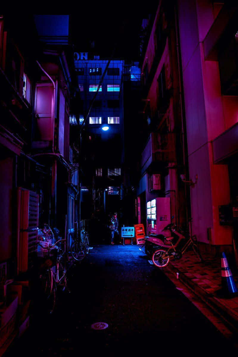 夜晚霓虹燈照亮的小巷，停有電單車和單車。