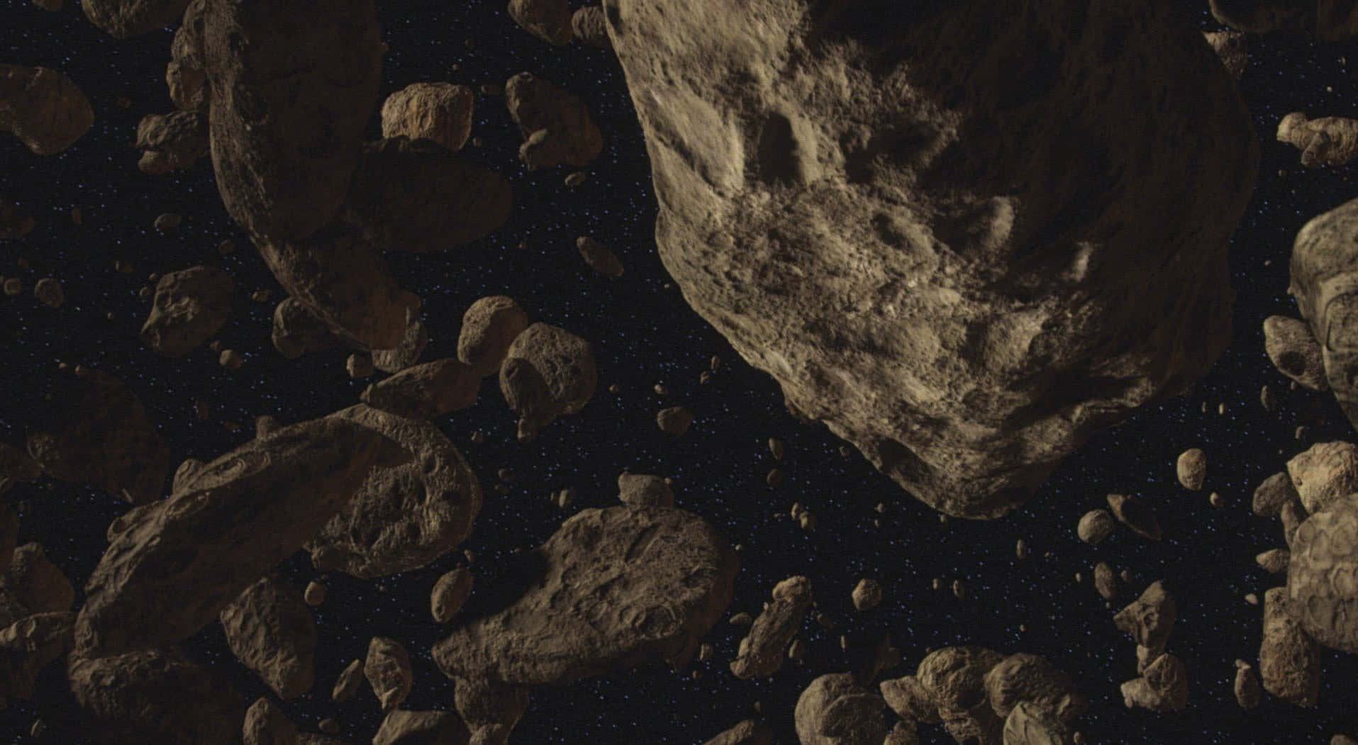 探索星際邊緣的太空奇景 壁紙 — 一片密集的崎嶇小行星在昏暗環境光下，飄過佈滿星星的虛空。