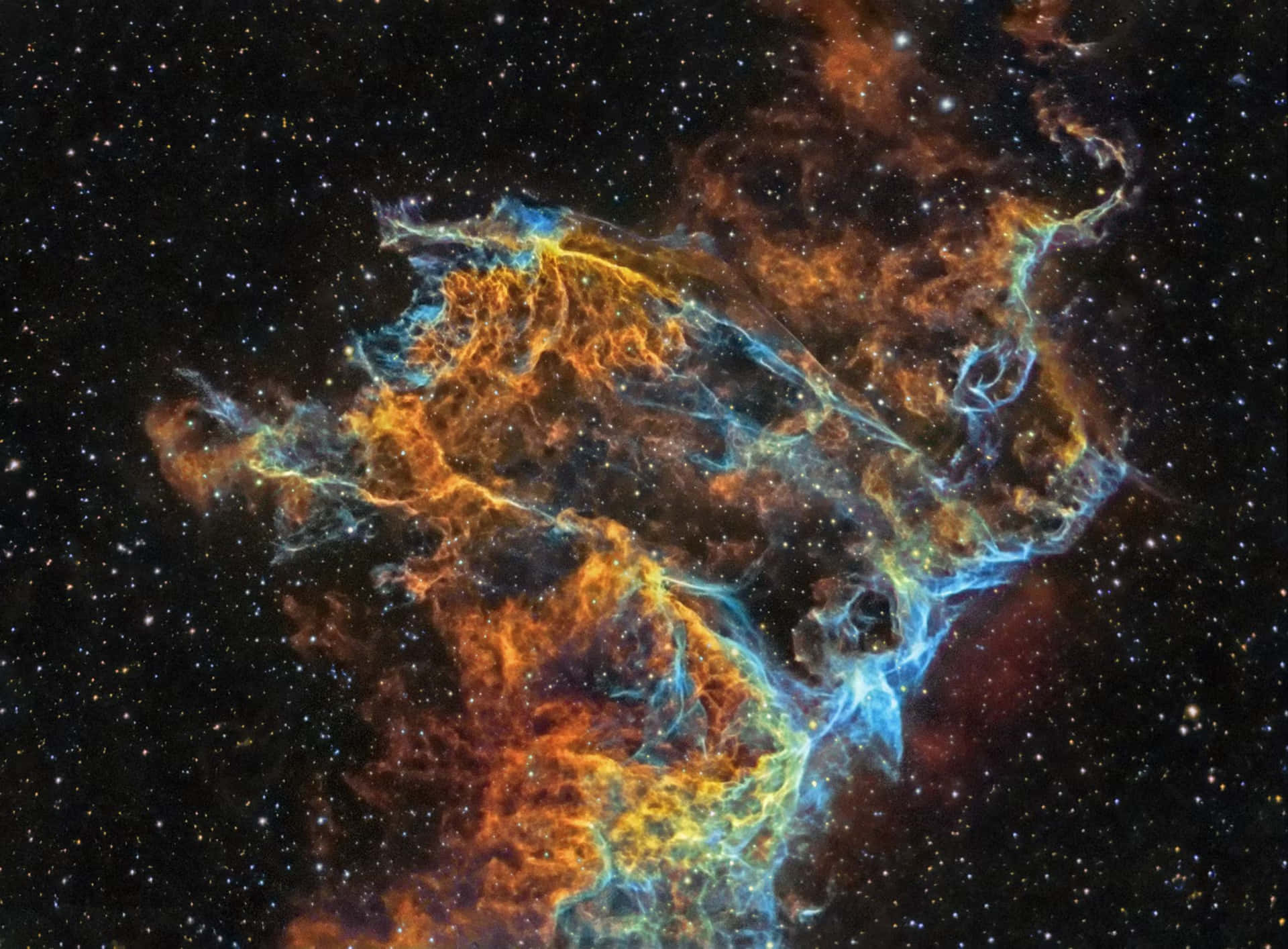 在深空星群中，一個色彩繽紛的星雲，帶有橙色和藍色的雲團。