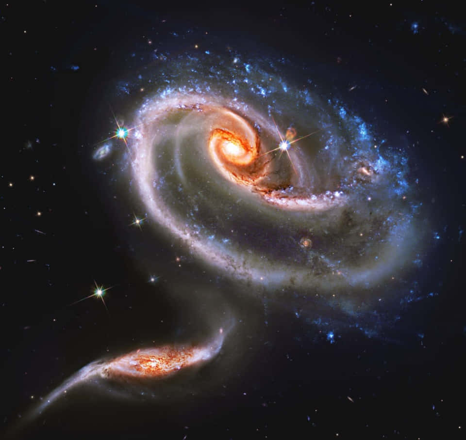一個充滿活力的螺旋星系，在深空中帶有發光的核心和藍色星團。