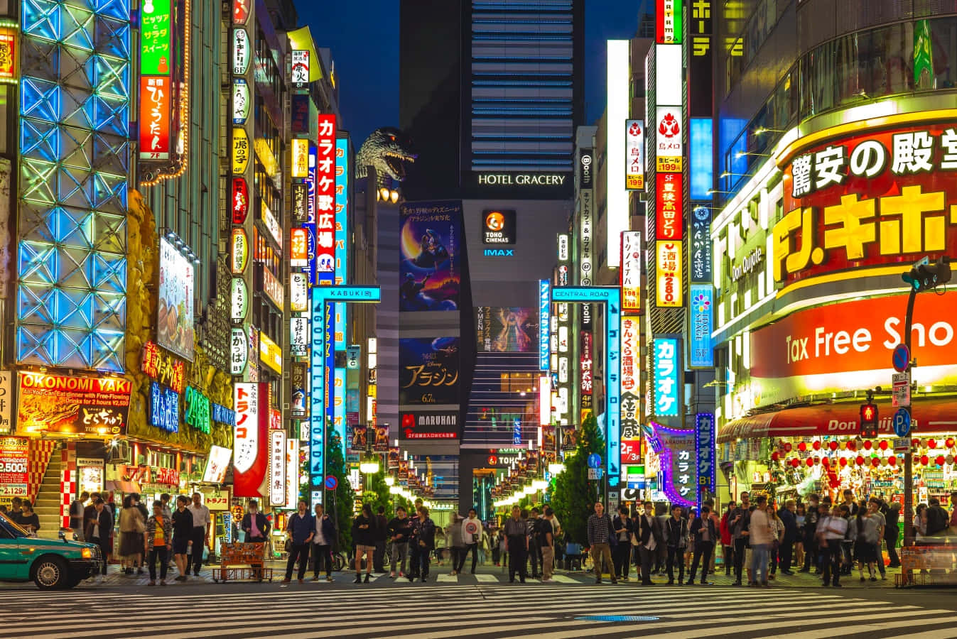 夜晚的東京街道，閃爍的霓虹燈招牌和行人穿過繁忙的十字路口。