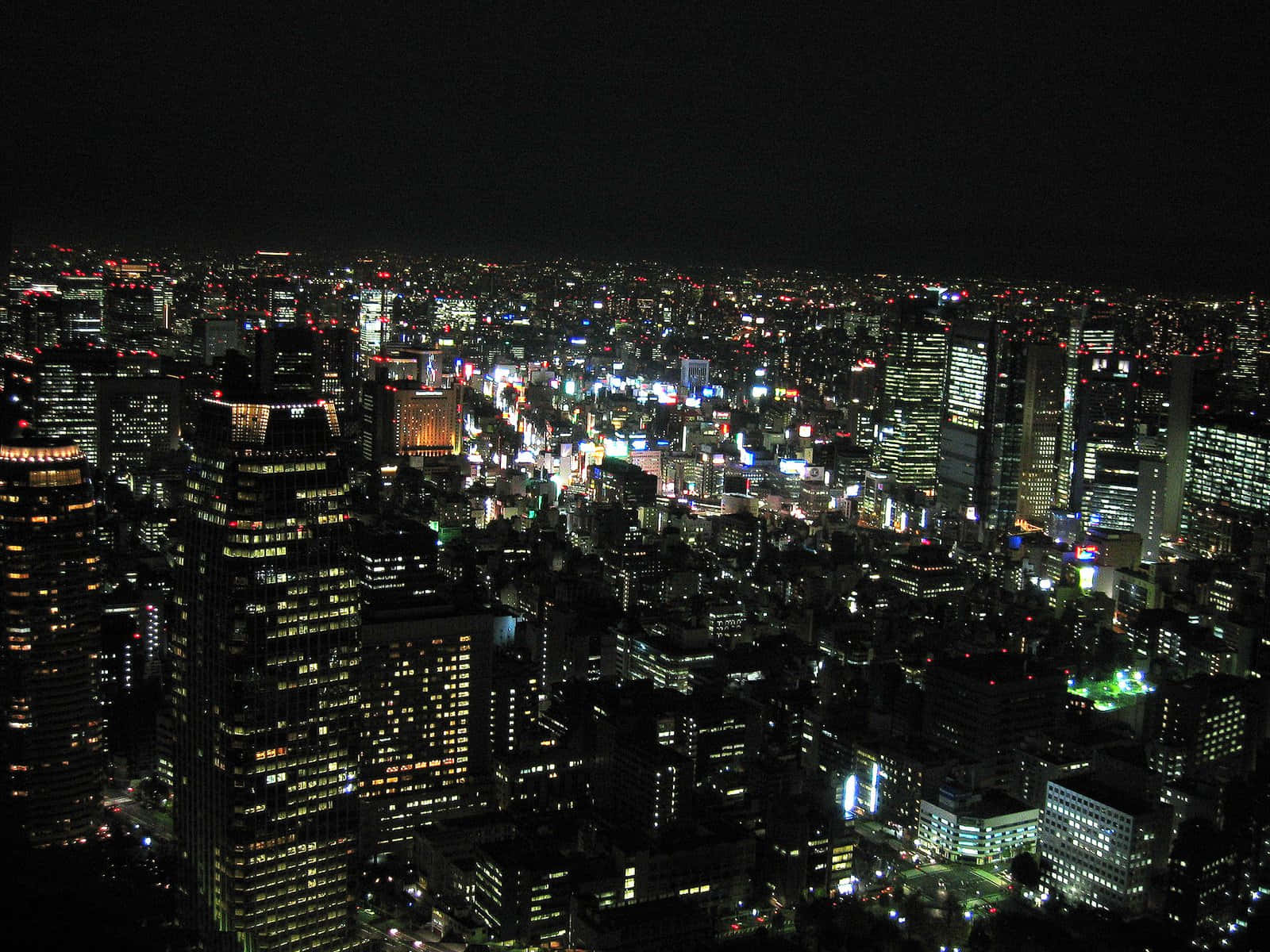 夜間城市景觀，摩天大樓和街道燈火通明。