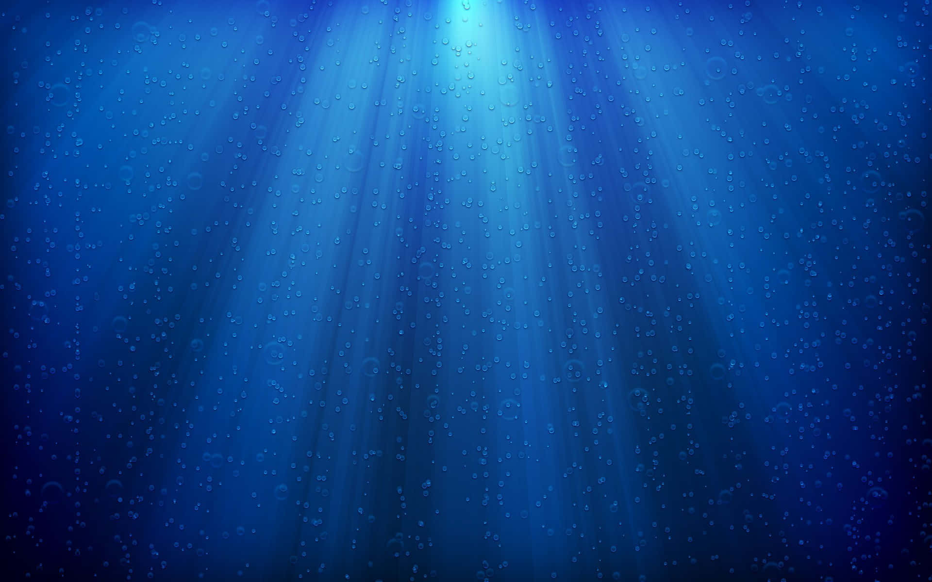陽光穿過深藍色海水，帶有漂浮的氣泡。
