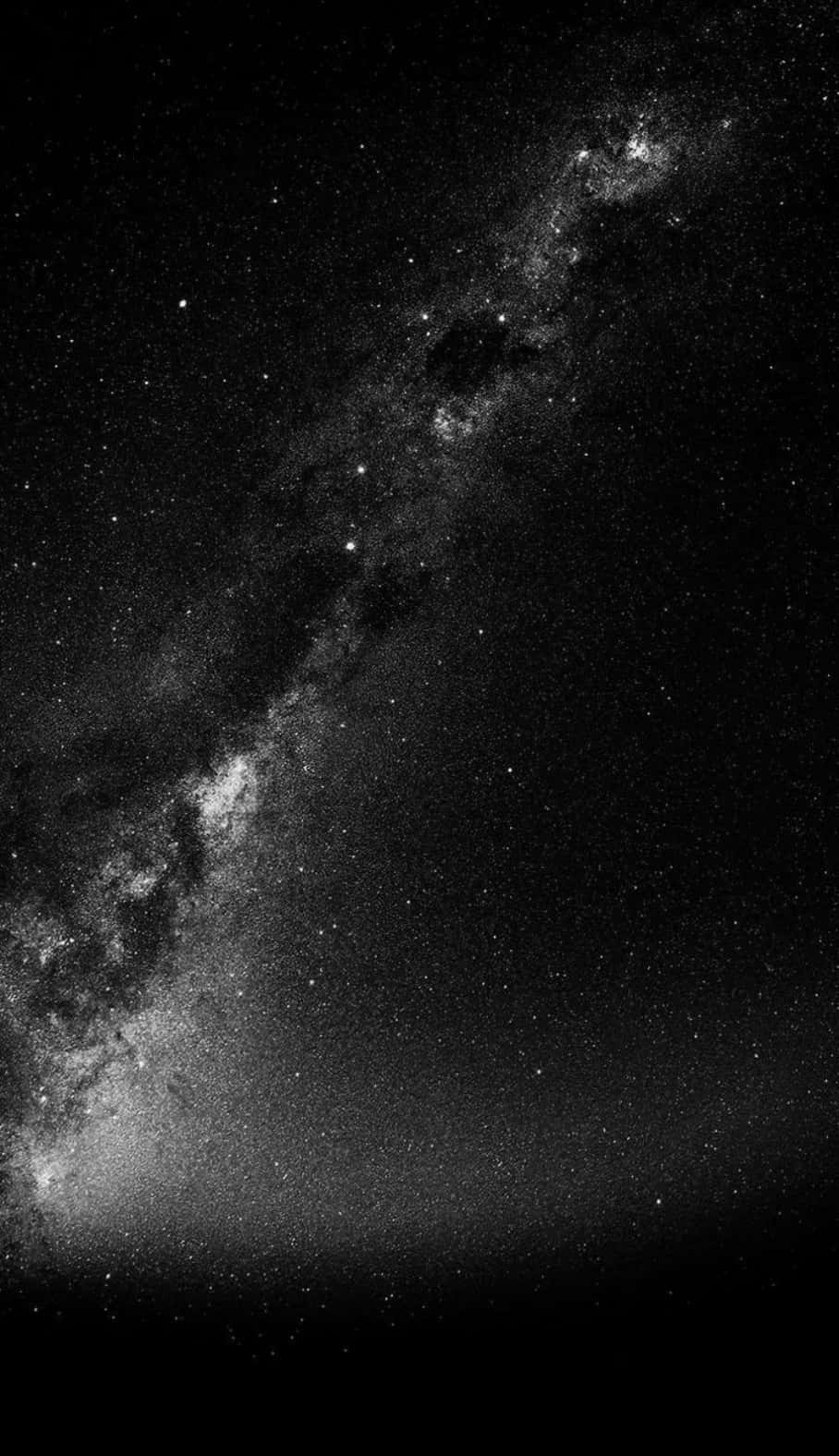 銀河系在繁星點點的夜空中以黑白色彩閃耀。