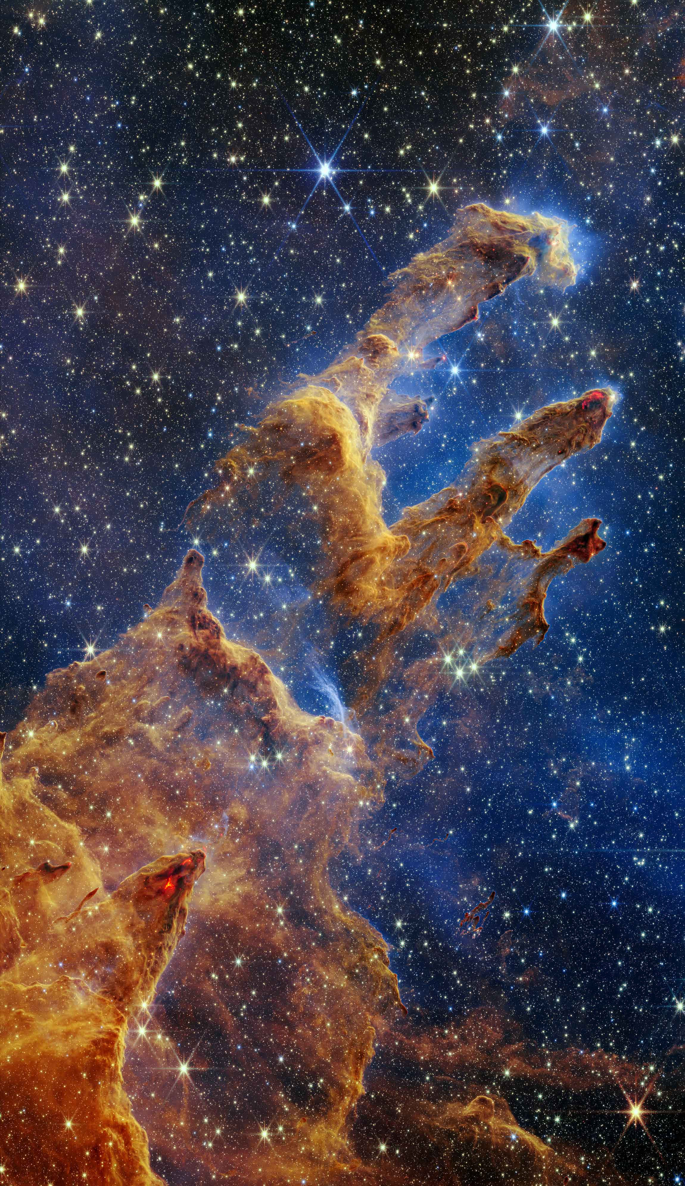 探索無垠未知 壁紙 — 宏偉的宇宙氣體和塵埃柱，由新生恆星照亮，背景是星場。