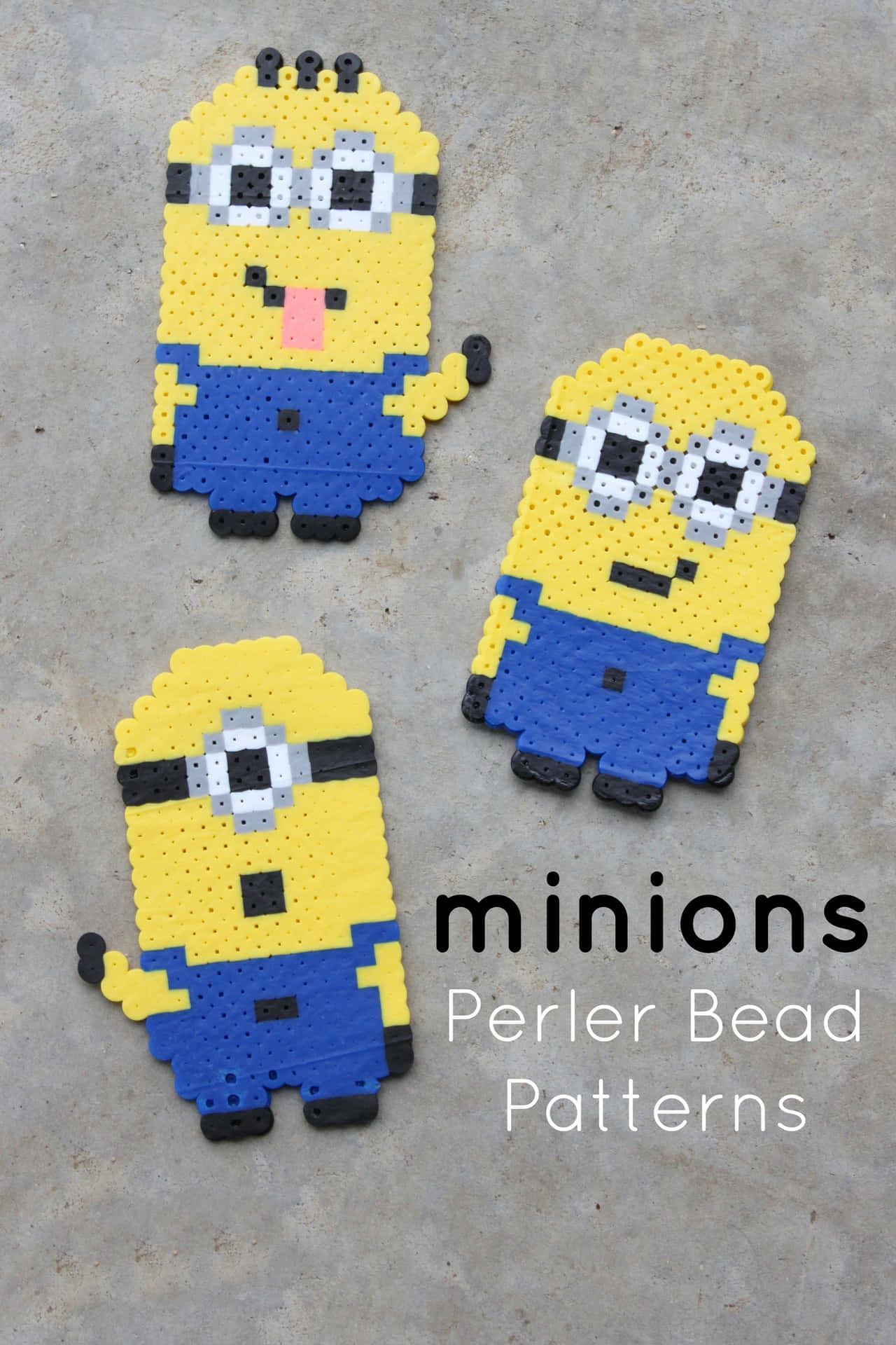 三個用彩色Perler珠子製成的Minion角色放在灰色表面上。