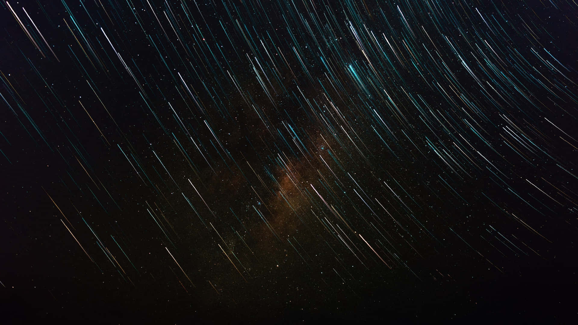 星軌弧線劃過黑暗的天空，顯露出發光的星雲。