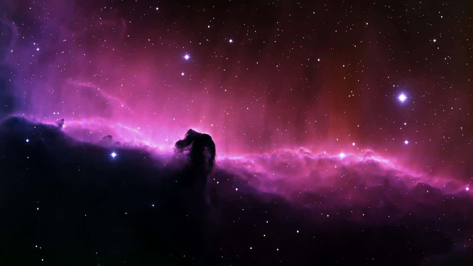 探索紫色宇宙的美麗 壁紙 — 宇宙星雲在星空背景下散發出充滿活力的紫色和粉紅色調，並帶有天體形成的黑暗剪影。