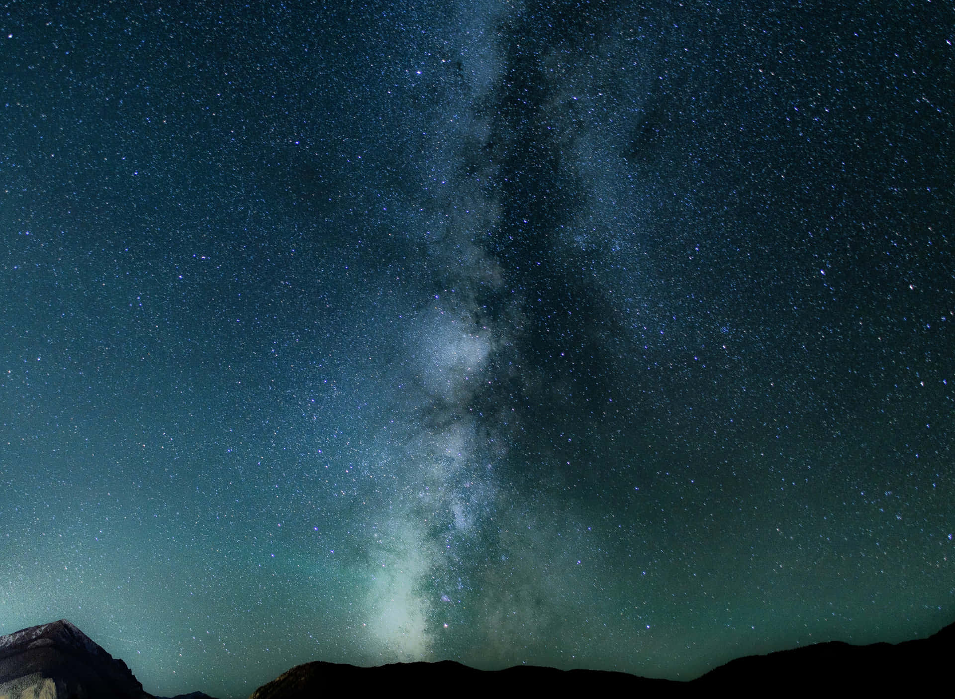 銀河系在繁星點點的夜空下，於山頂上方閃耀。