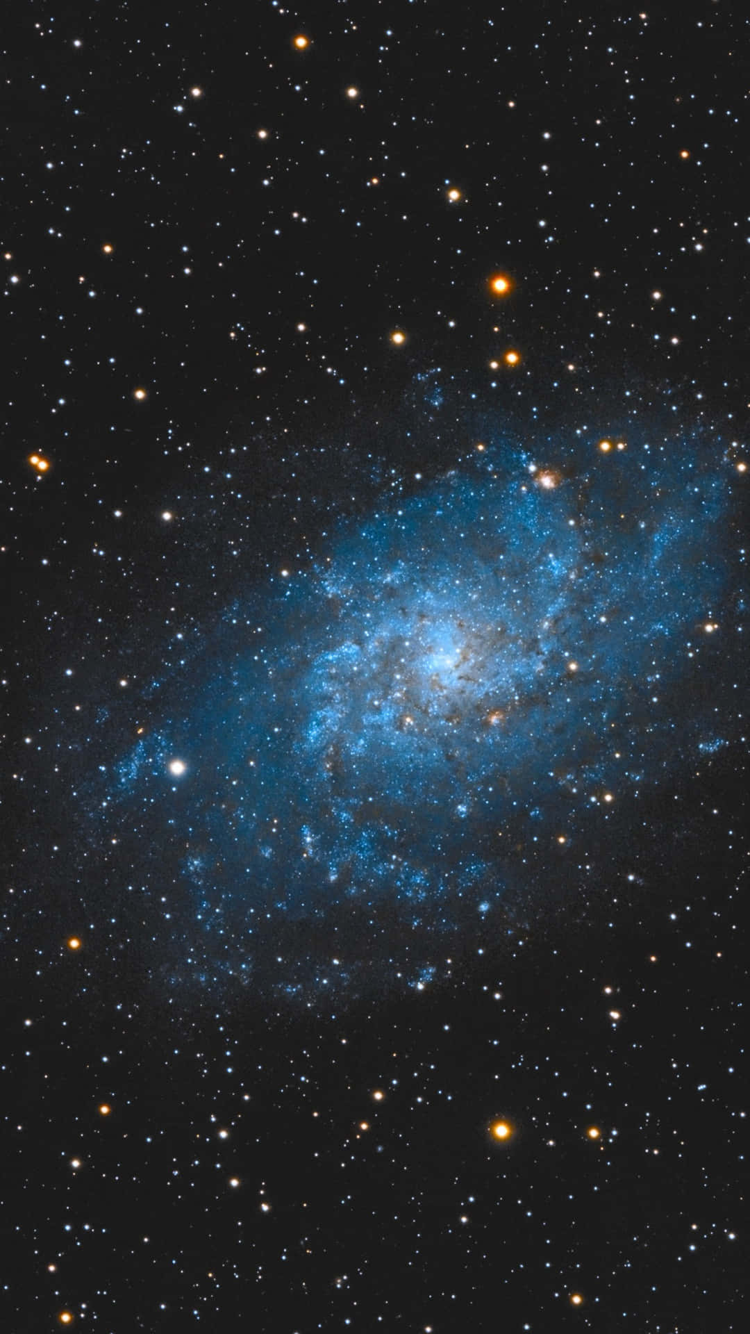 一個充滿活力的螺旋星系，在深空中有藍色星團和橙色星星。
